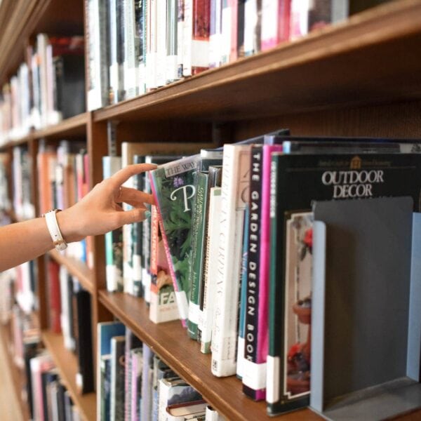 Person Holding Book from Shelf